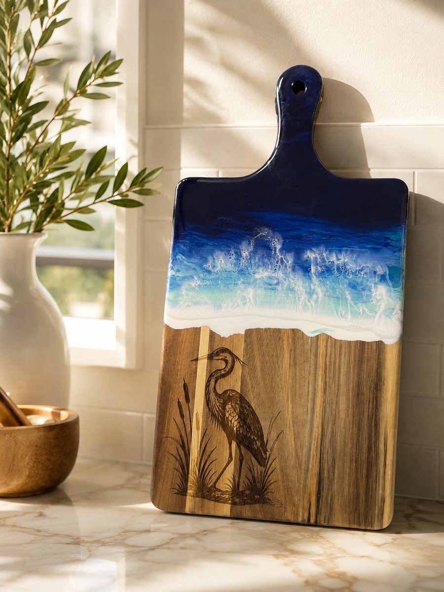 Acacia serving board with blue resin waves and an engraved heron